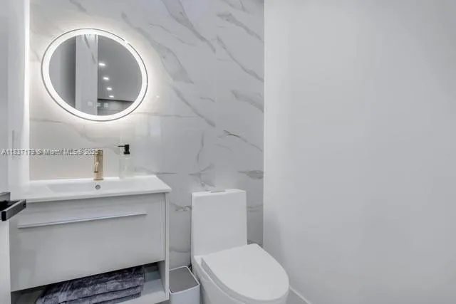 a bathroom with a toilet a sink and a mirror