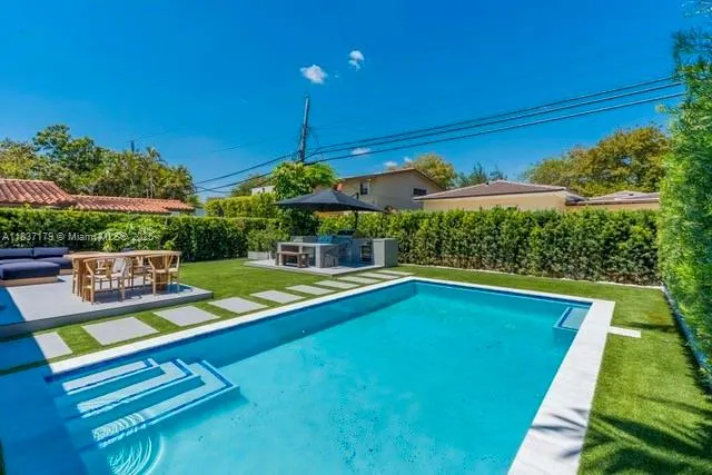 a view of a backyard with swimming pool