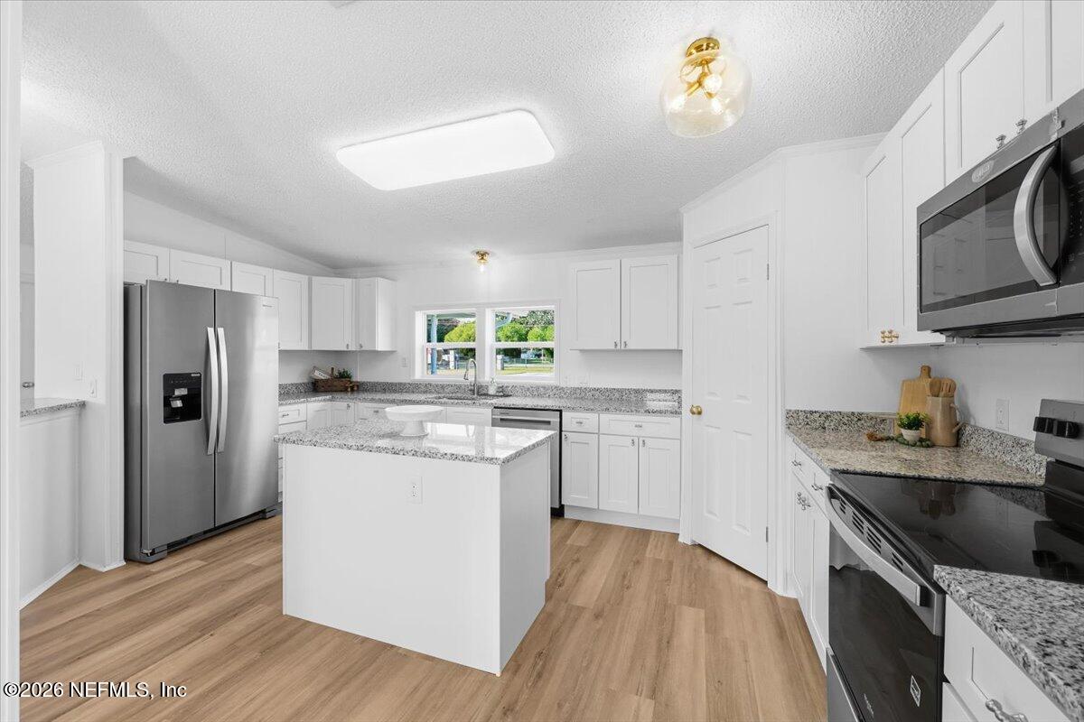 345 Jones Road Jacksonville, FL 32220 - Photo 16 of 32 a kitchen with stainless steel appliances granite countertop a sink stove and refrigerator