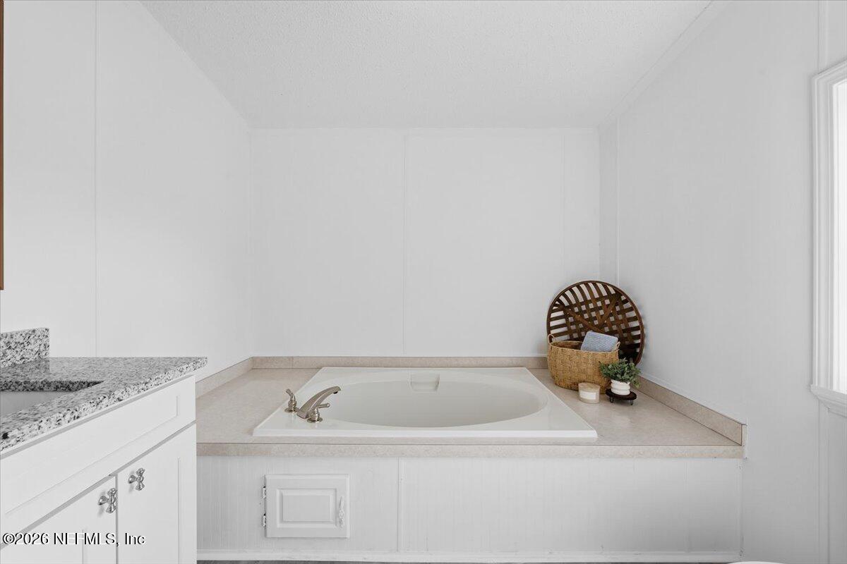 345 Jones Road Jacksonville, FL 32220 - Photo 25 of 32 a bathroom with a granite countertop sink and a mirror
