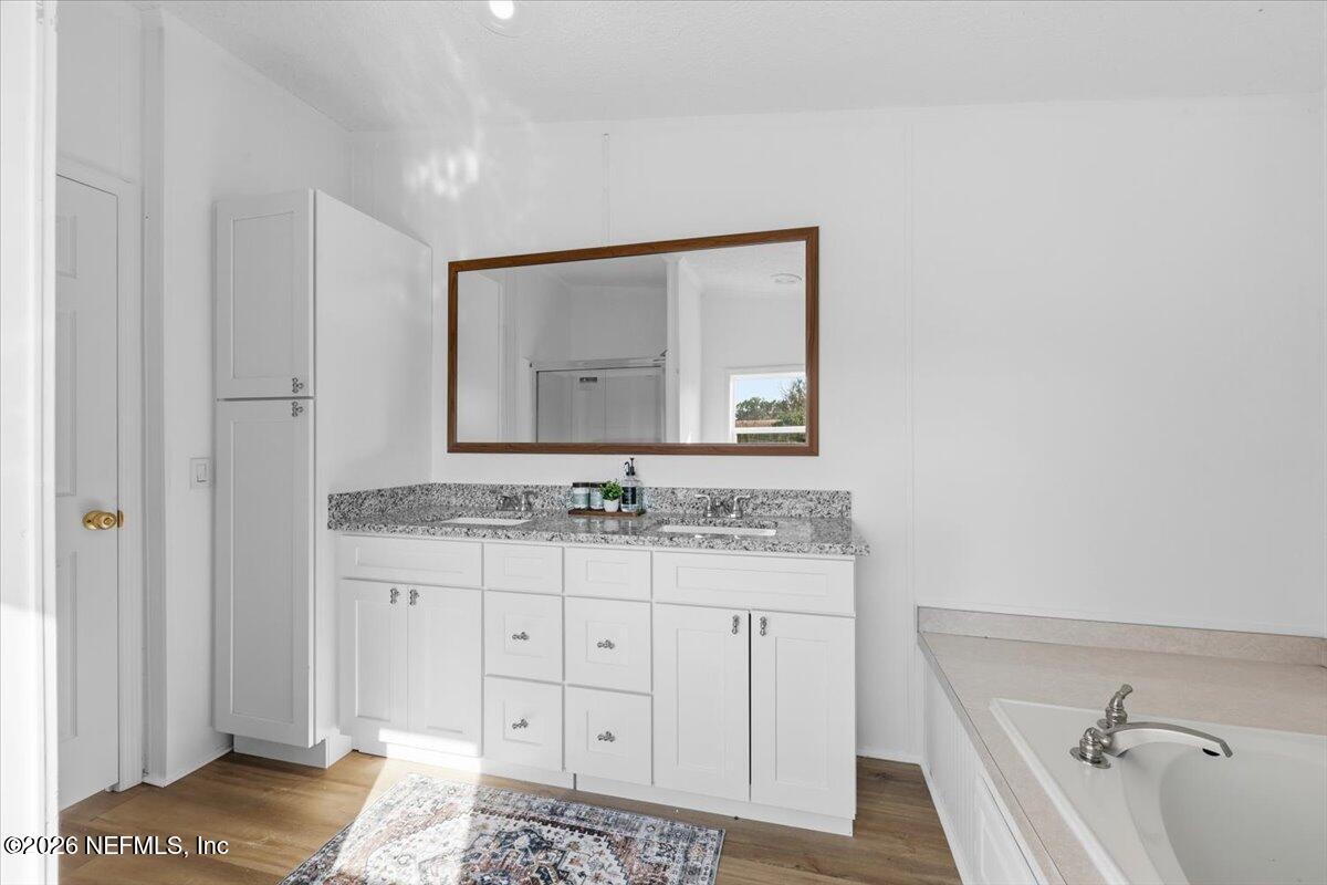 345 Jones Road Jacksonville, FL 32220 - Photo 27 of 32 a bathroom with a granite countertop sink and a mirror