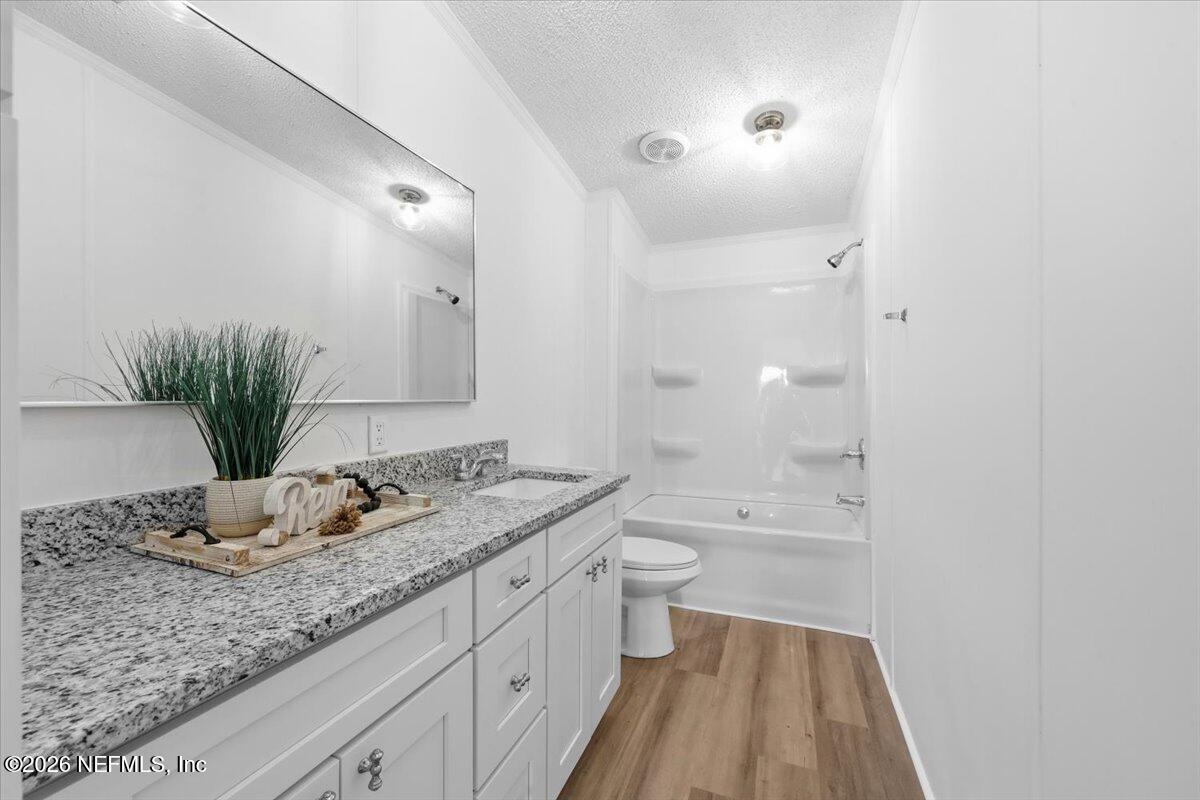 345 Jones Road Jacksonville, FL 32220 - Photo 29 of 32 a bathroom with a granite countertop sink a toilet and shower