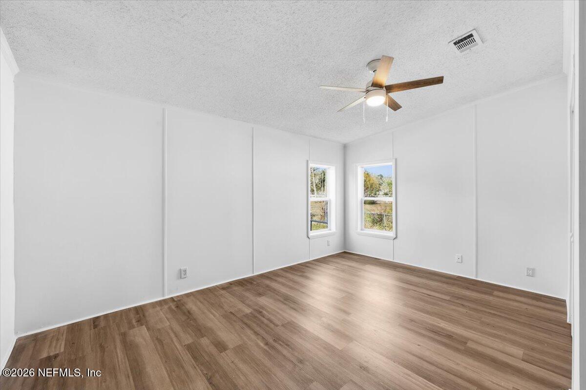 345 Jones Road Jacksonville, FL 32220 - Photo 31 of 32 a view of empty room with wooden floor and fan