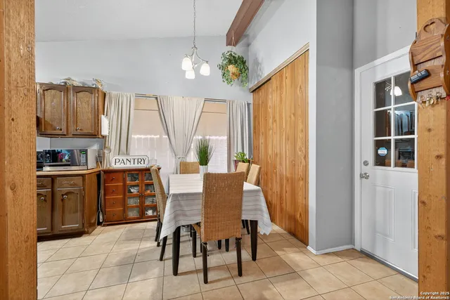 a dining room with stainless steel appliances a table and chairs