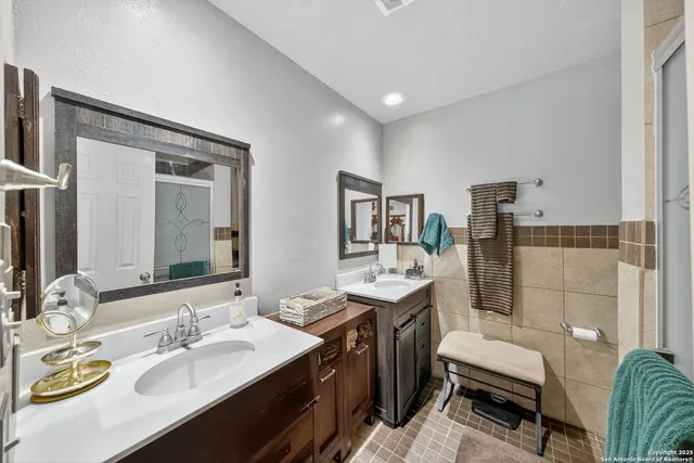 a en suite bathroom with a double vanity sink and a mirror