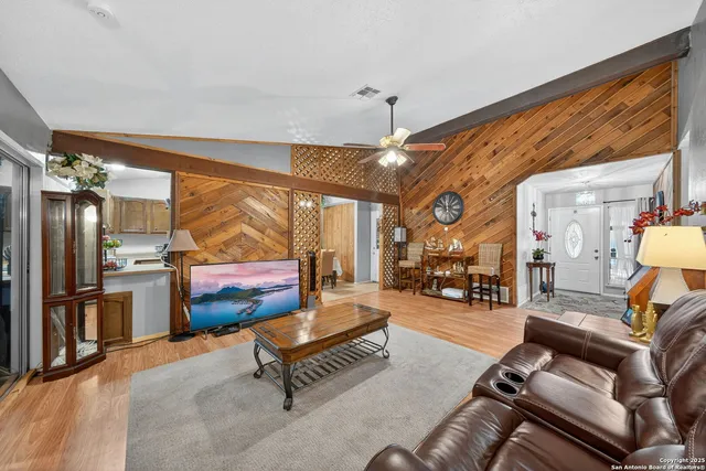a living room with furniture a dining table and chairs with a large window