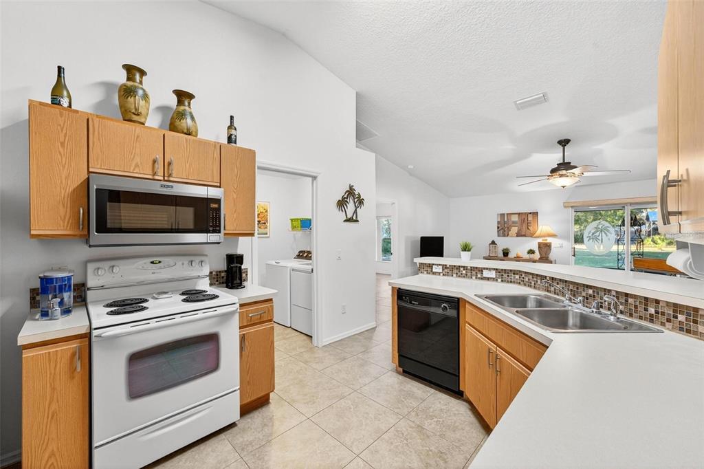 3859 Southwest 109th Lane Ocala, FL 34476 - Photo 10 of 55 a kitchen with stainless steel appliances granite countertop a stove top oven a sink a refrigerator and white cabinets with wooden floor
