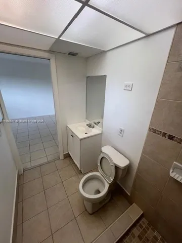 a white toilet sitting next to a bathroom sink and vanity