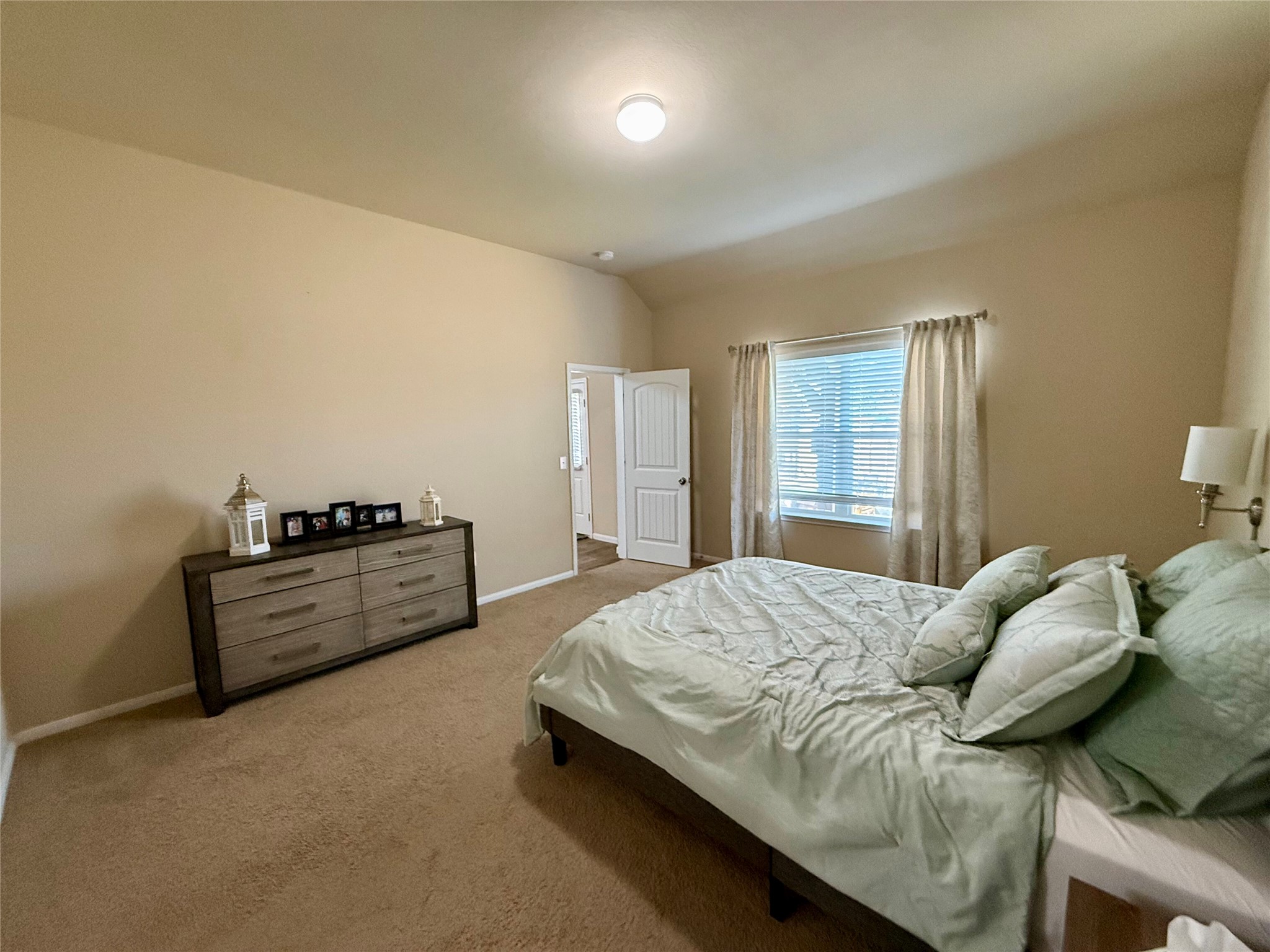 11700 Andesite Road Manor, TX 78653 - Photo 8 of 32 Well-lit bedroom with carpeted flooring and ample space, offering comfort and tranquility.