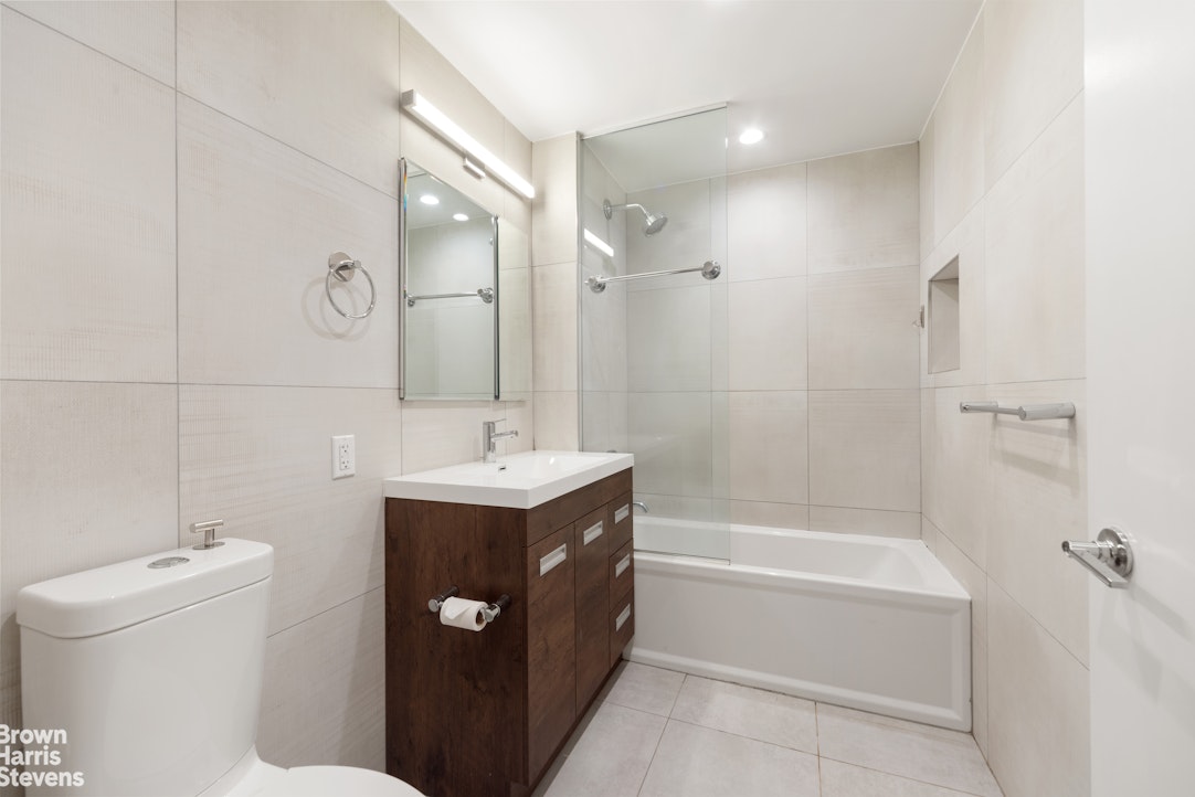 131 Devoe Street, Unit 4C Brooklyn, NY 11211 - Photo 4 of 10 a bathroom with a sink a toilet and shower