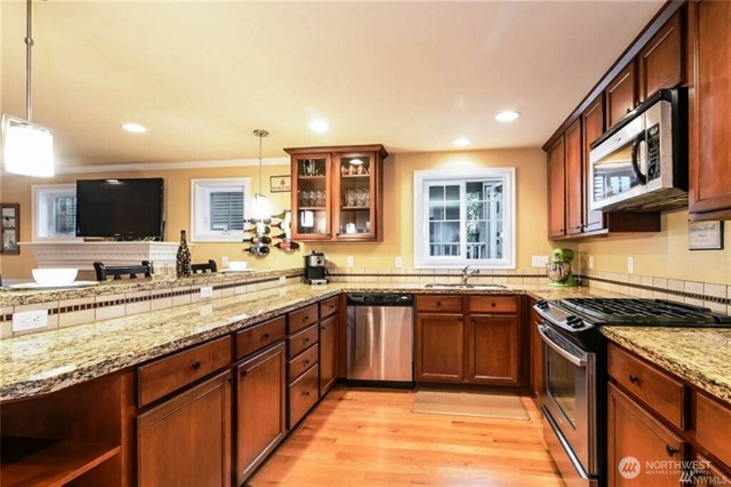 725 North 95th Street, Unit C Seattle, WA 98103 - Photo 7 of 18 a kitchen with stainless steel appliances granite countertop a stove sink and cabinets