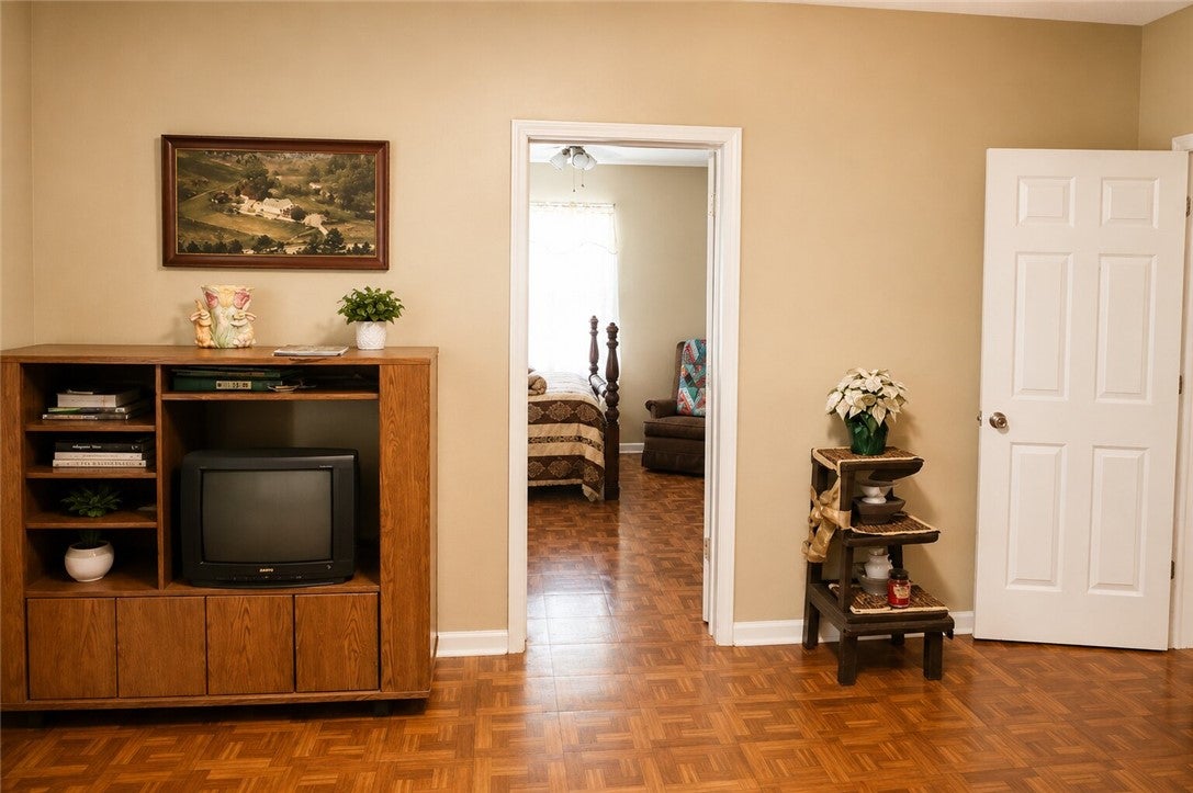 1075 Lowe Road Notasulga, AL 36866 - Photo 12 of 16 This interior offers classic wood flooring, leading to a cozy bedroom.