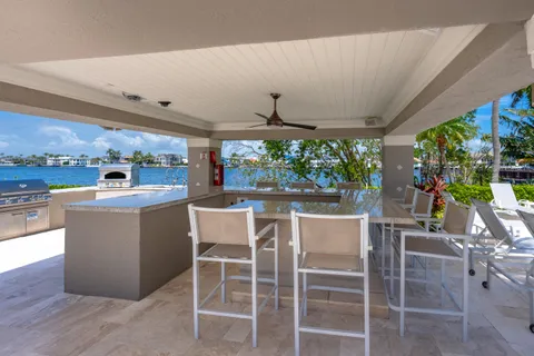 a open kitchen with stainless steel appliances granite countertop a barbecue grill and couches chair with outer view
