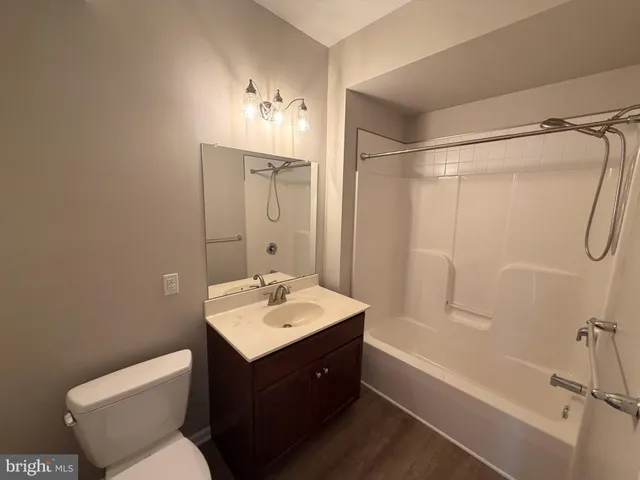 a bathroom with a sink vanity mirror and toilet