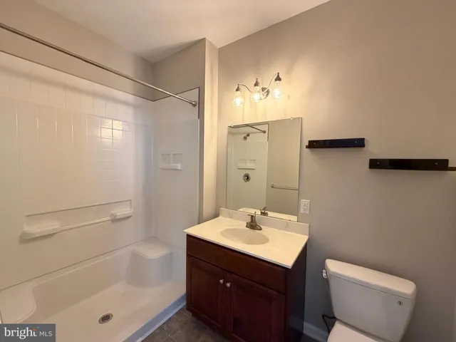 a bathroom with a sink toilet a mirror and shower