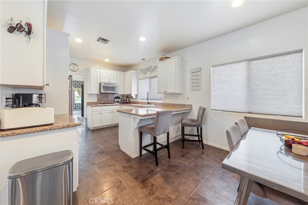 1842 Balboa Way Upland, CA 91784 - Photo 12 of 70 a kitchen with a table chairs refrigerator and microwave