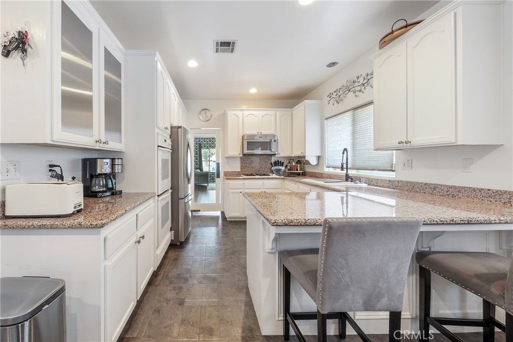 1842 Balboa Way Upland, CA 91784 - Photo 13 of 70 a kitchen with granite countertop stainless steel appliances a sink a counter top space and cabinets