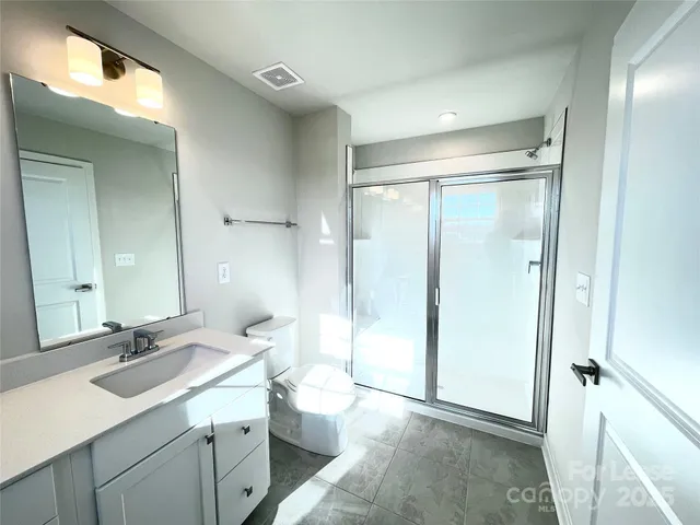 a bathroom with a double vanity sink mirror and shower