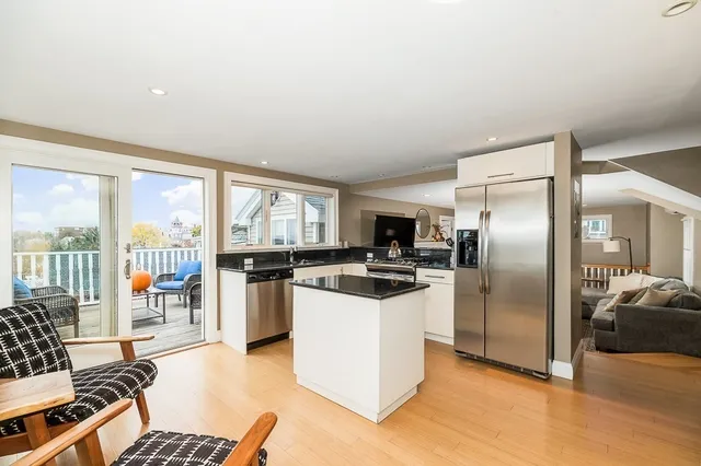 a kitchen with stainless steel appliances kitchen island granite countertop a refrigerator and a stove top oven