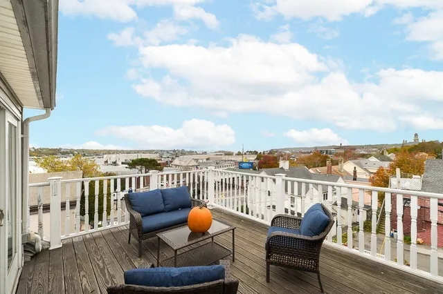 a view of a balcony with wooden floor chairs and a table
