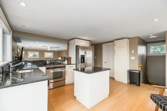 a kitchen with stainless steel appliances granite countertop a sink stove and refrigerator