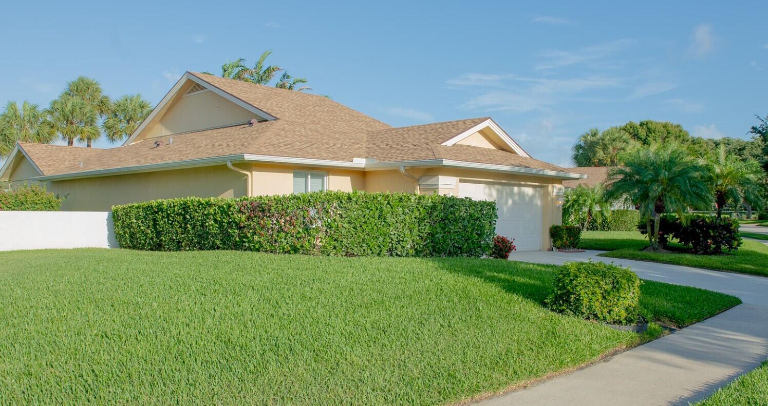 114 Beach Summit Court Jupiter, FL 33477 - Photo 4 of 32 a front view of a house with a yard and potted plants