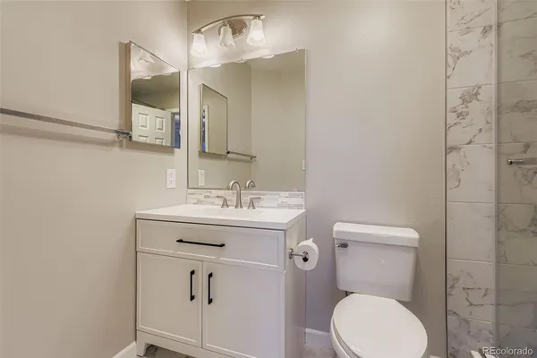 a bathroom with a toilet a sink and mirror