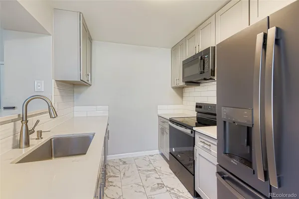 a kitchen with stainless steel appliances a refrigerator sink and microwave