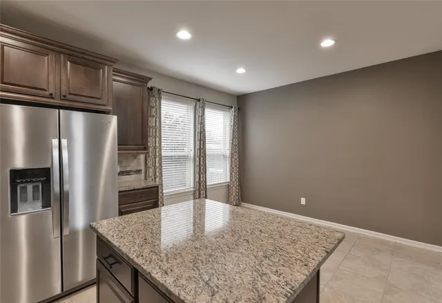 a open kitchen with refrigerator stove and kitchen island