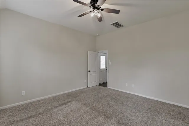 a view of an empty room and chandelier fan