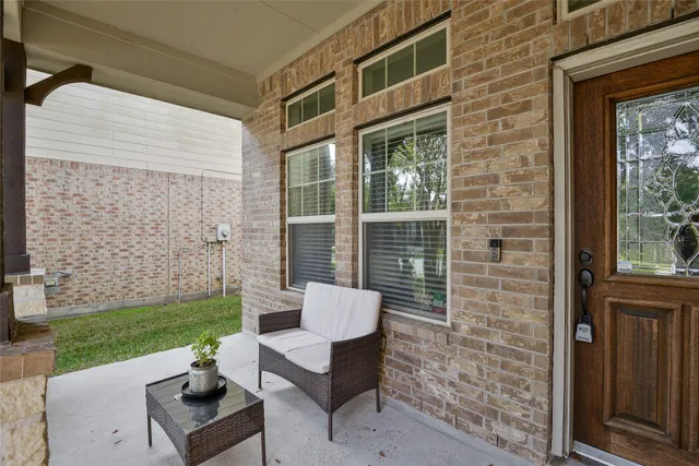 a view of a chair and table in the back yard of the house