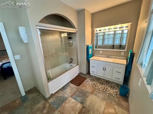 a bathroom with a bathtub sink and mirror