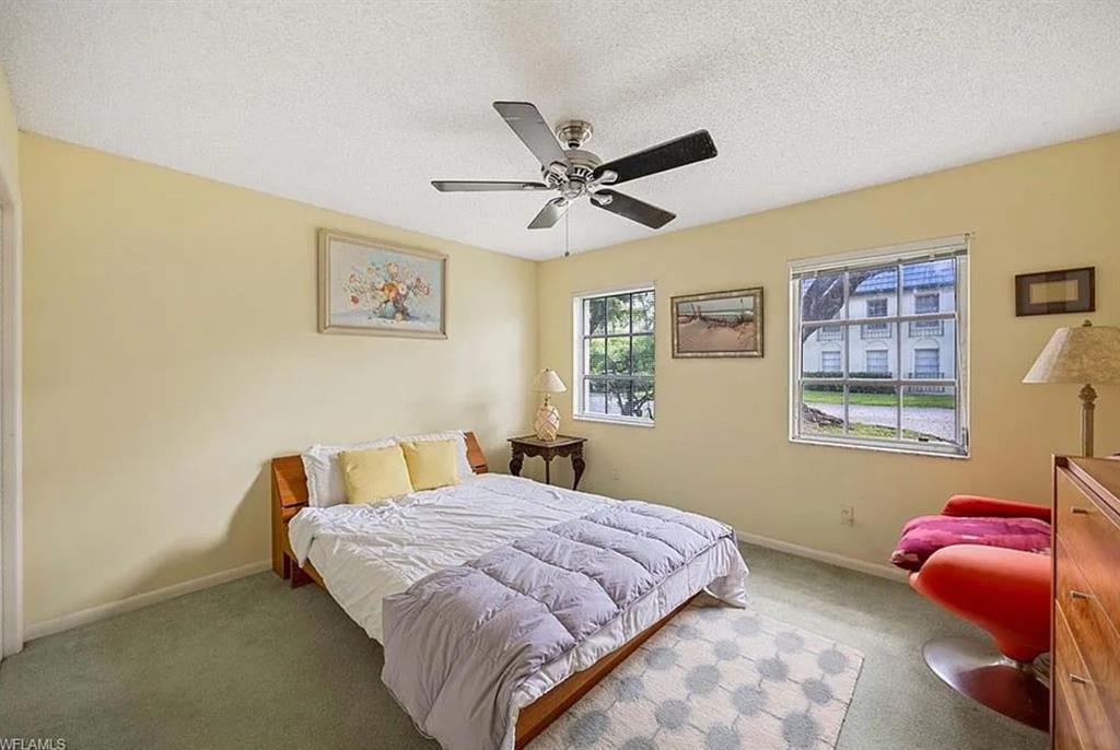 209 Bobolink Way, Unit A Naples, FL 34105 - Photo 13 of 17 a bedroom with a bed and a painting on the wall