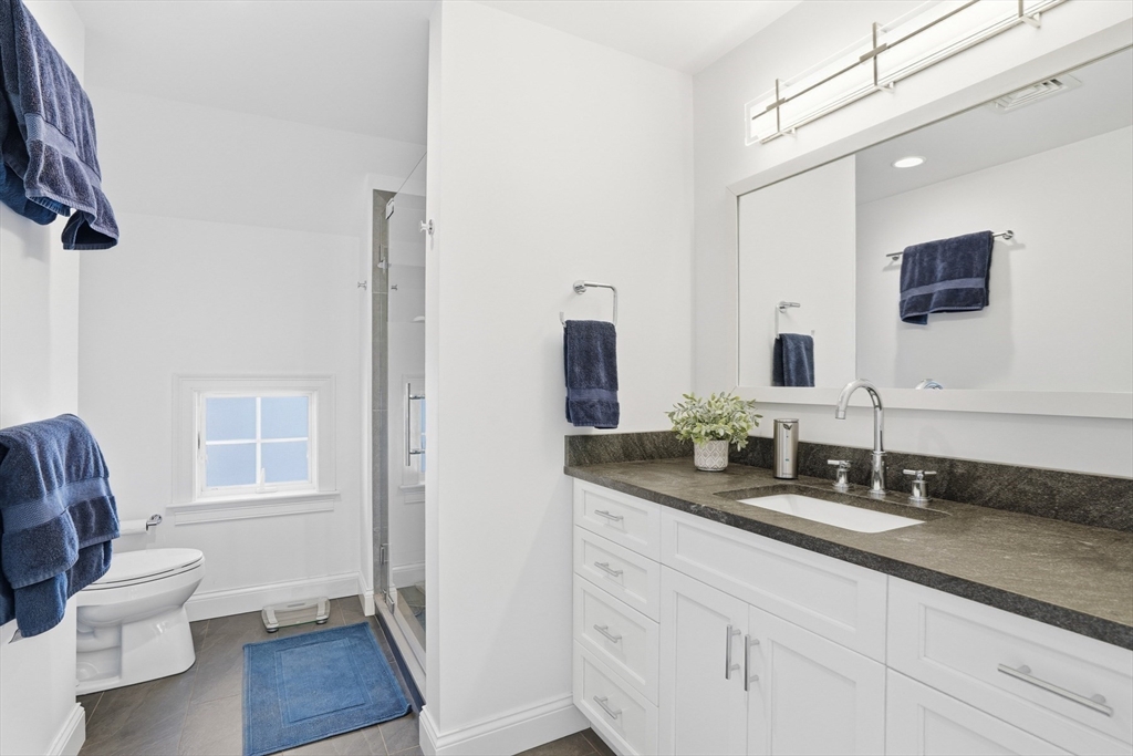 25 Bold Meadow Road Edgartown, MA 02539 - Photo 23 of 40 a bathroom with a granite countertop sink a toilet a mirror and shower