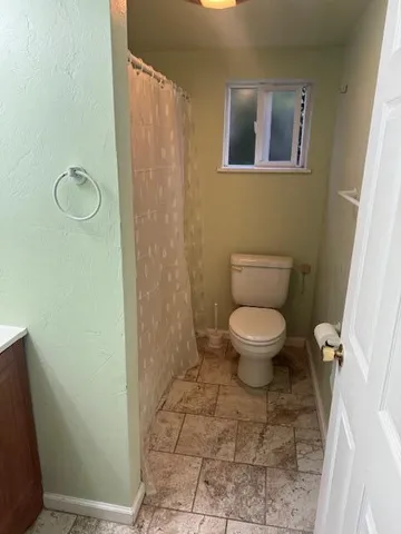 a bathroom with a toilet and a shower