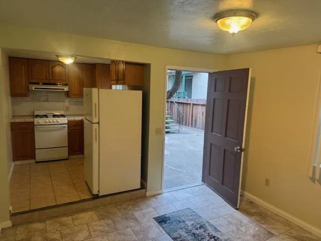 a view of a kitchen with a refrigerator a stove top oven a sink and dishwasher