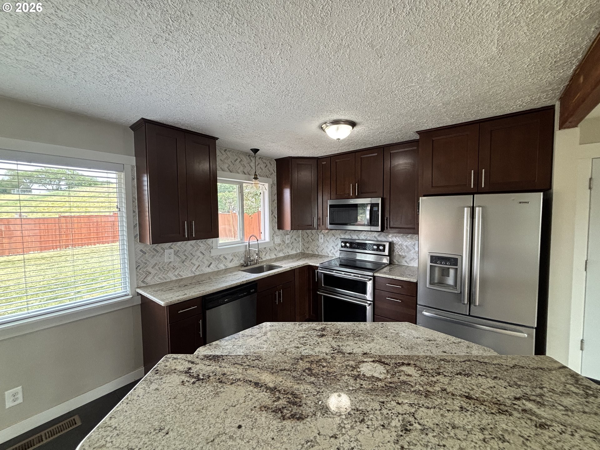 924 Southwest 33rd Street Pendleton, OR 97801 - Photo 4 of 27 a kitchen with granite countertop a refrigerator stove top oven and sink