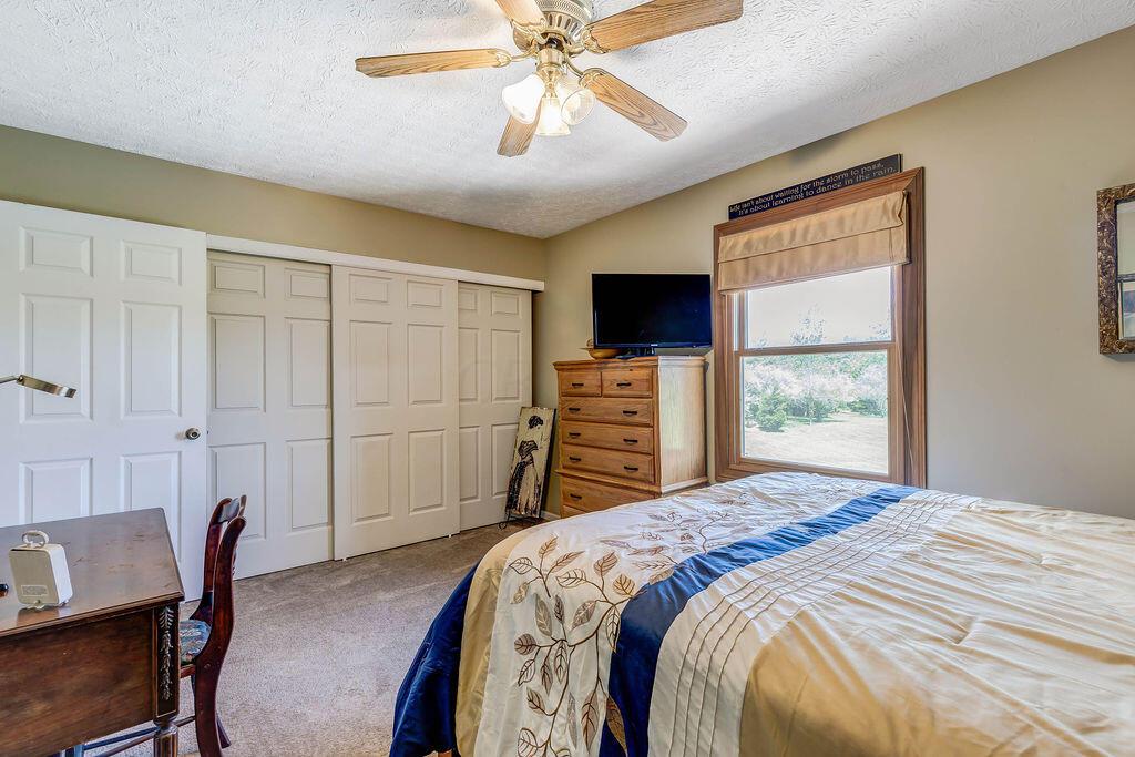 1300 Hubbard Road Galloway, OH 43119 - Photo 43 of 89 • Tan carpet • Dark beige painted walls • Lighted ceiling fan • Closet with three sliding doors • Shades remain