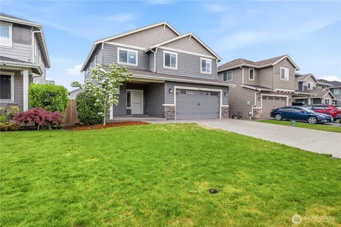 a front view of a house with a yard and garage
