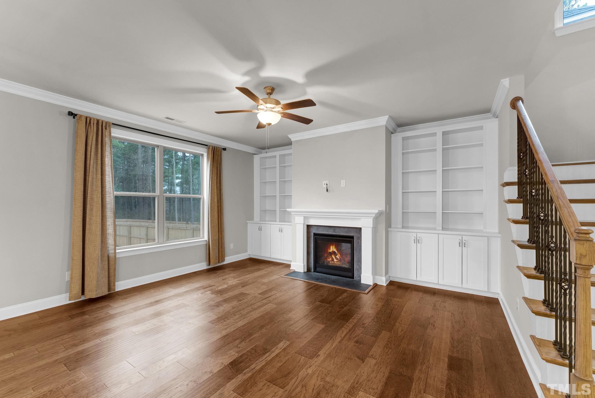 928 Barringer Drive Raleigh, NC 27606 - Photo 11 of 32 a view of an empty room with wooden floor fireplace and a window