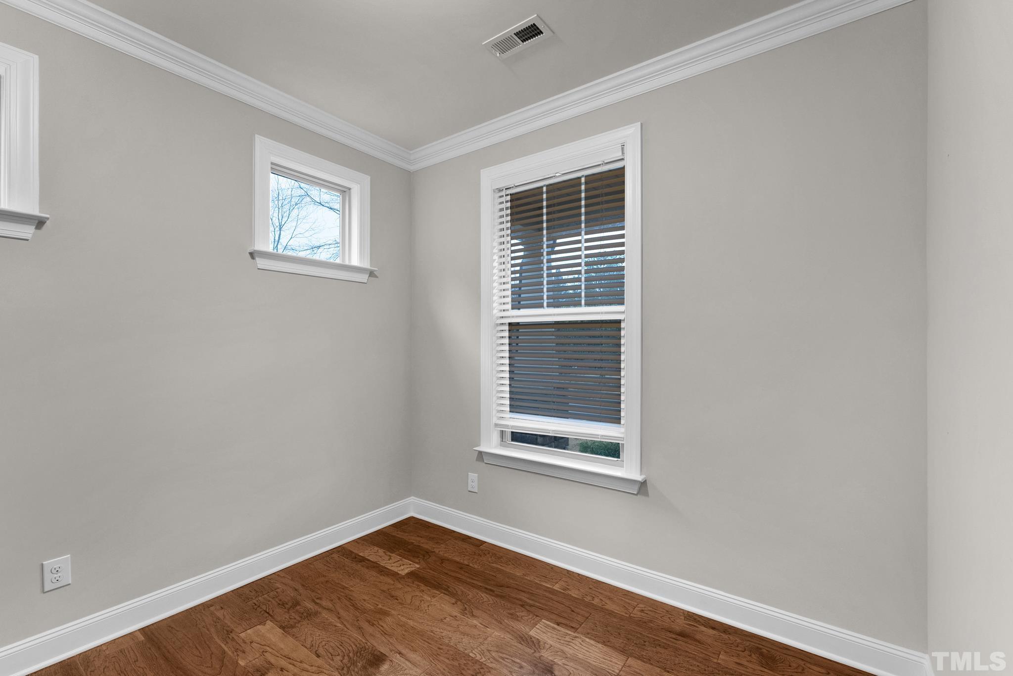 928 Barringer Drive Raleigh, NC 27606 - Photo 31 of 32 an empty room with wooden floor and windows