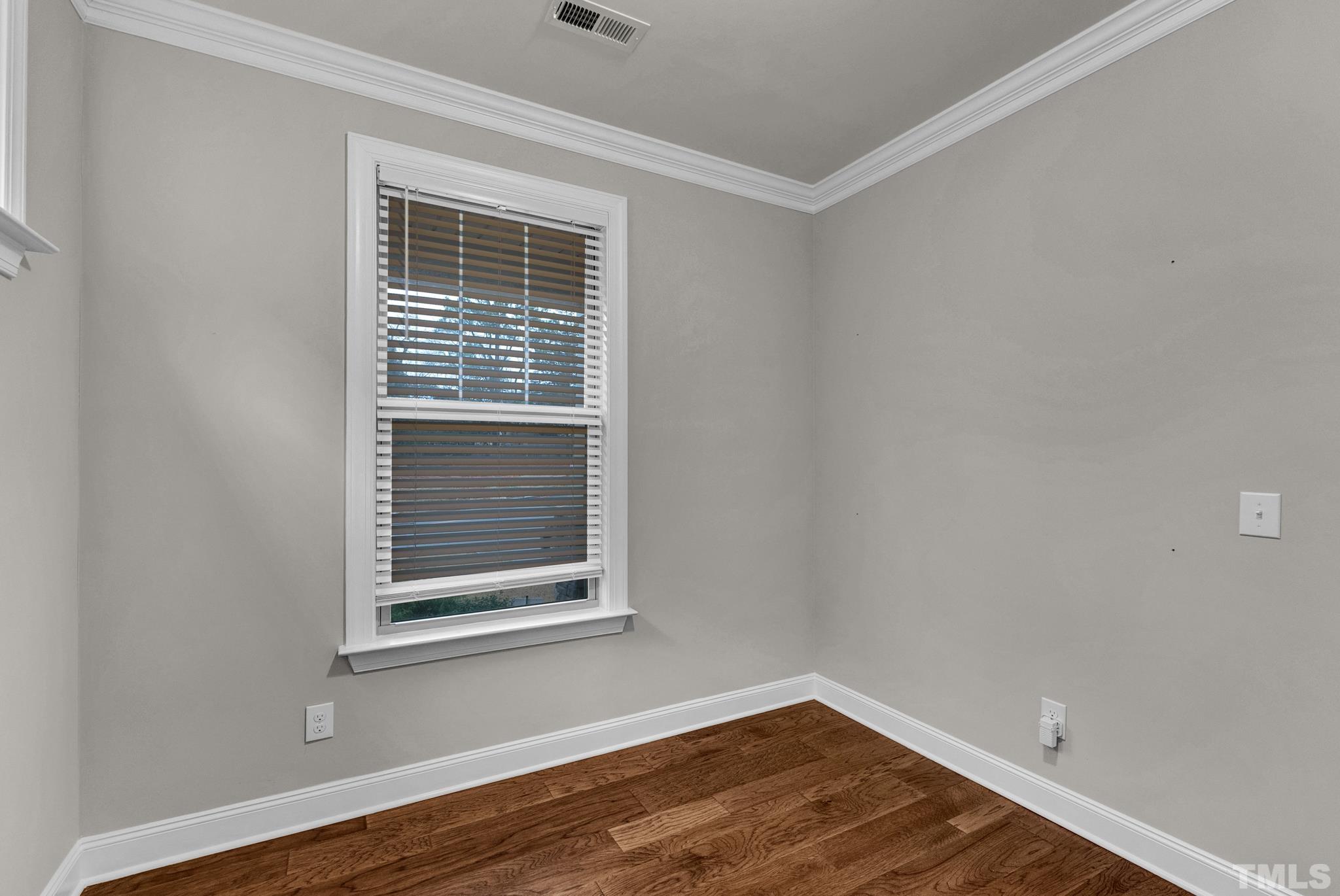 928 Barringer Drive Raleigh, NC 27606 - Photo 32 of 32 a view of an empty room with wooden floor and a window