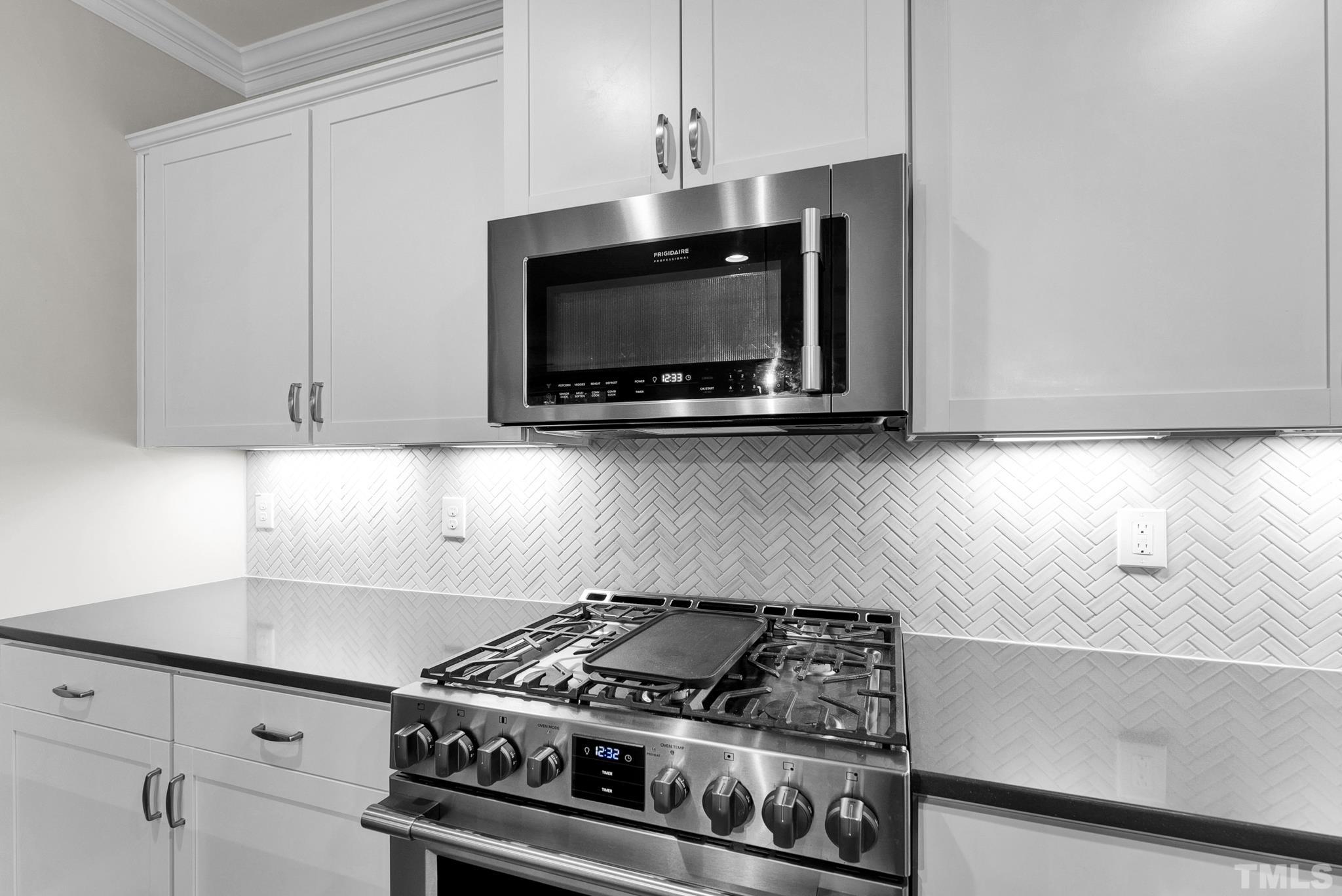 928 Barringer Drive Raleigh, NC 27606 - Photo 5 of 32 a kitchen with granite countertop a stove and a microwave