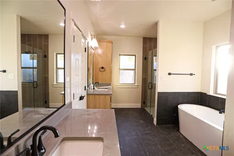 a spacious bathroom with a granite countertop tub sink and mirror