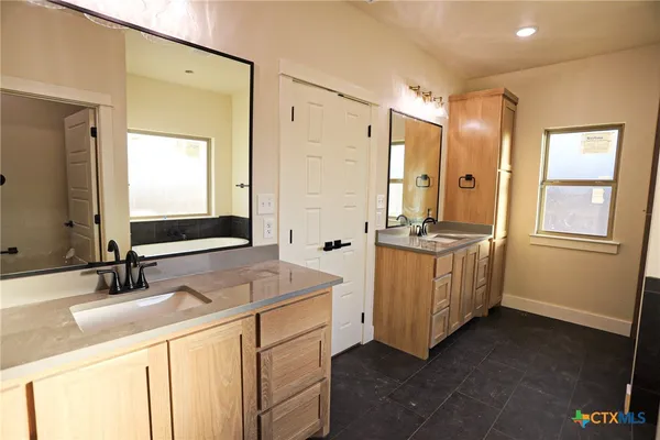 a bathroom with double vanity and a mirror