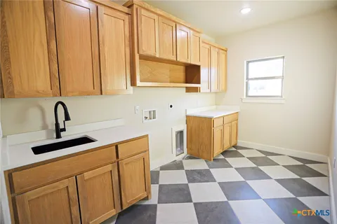 a kitchen with stainless steel appliances a sink a stove a refrigerator and cabinets