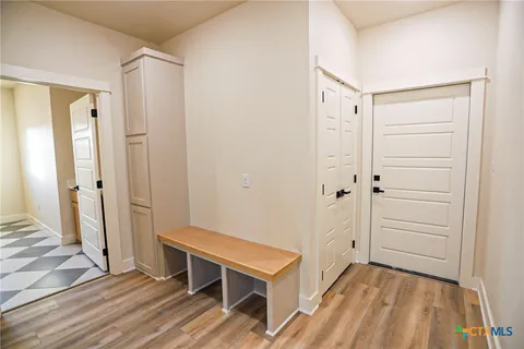 a view of a hallway with wooden floor and entryway
