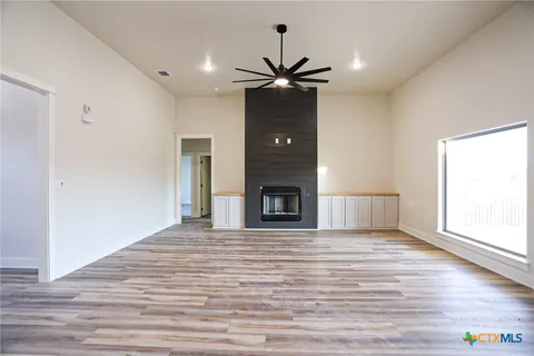 a view of an empty room with a window and a fireplace