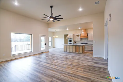 a view of kitchen with kitchen island wooden floor and refrigerator