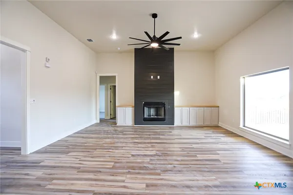 a view of an empty room with a window and a fireplace